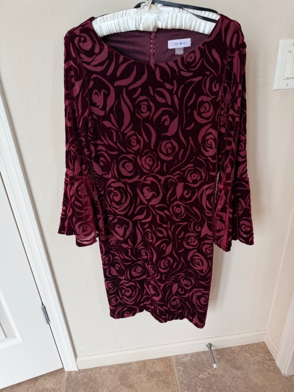 Calvin Klein Burgundy embossed velvet sheath dress with bell sleeves.